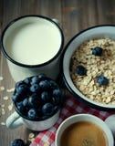 Sunt äta, mat och bantar begrepp - den smakliga havremjölet med bär och en råna av mjölkar och en kopp kaffe Top beskådar royaltyfri bild Sunt äta, mat och bantar begrepp - den smakliga havremjölet med bär och en råna av mjölkar och en kopp kaffe Top beskådar royaltyfri bild