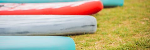 SUP scheept het liggen op het gras door de rivier, meer of overzeese BANNER, LANG FORMAAT in stock afbeeldingen SUP scheept het liggen op het gras door de rivier, meer of overzeese BANNER, LANG FORMAAT in stock afbeeldingen