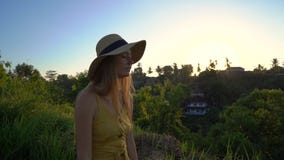 Super slowmotion shot of a young woman in a yellow dress walking during sunset at the Campuhan ridge walk or painter`s stock video footage Super slowmotion shot of a young woman in a yellow dress walking during sunset at the Campuhan ridge walk or painter`s stock video footage