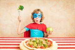 Superheldkind, das superfood isst lizenzfreie stockfotografie Superheldkind, das superfood isst lizenzfreie stockfotografie