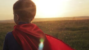 Superhero αγοριών σε έναν τομέα στο ηλιοβασίλεμα Superhero αγοριών σε έναν τομέα στο ηλιοβασίλεμα