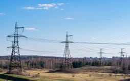 Supports high-voltage power lines against the blue sky with clouds. Electrical industry royalty free stock photography Supports high-voltage power lines against the blue sky with clouds. Electrical industry royalty free stock photography