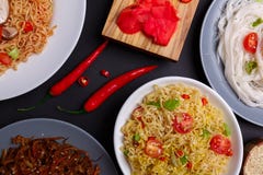 Sur la table, les plats de différents types de nouilles, le piment et le gingembre Vue de ci-avant photographie stock Sur la table, les plats de différents types de nouilles, le piment et le gingembre Vue de ci-avant photographie stock