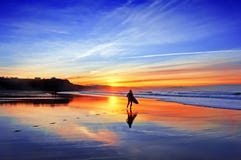 Surfer in beach at sunset. Surfer in the beach at sunset stock photos Surfer in beach at sunset. Surfer in the beach at sunset stock photos