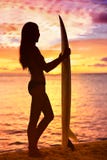 Surfermädchen, das Ozeanstrandsonnenuntergang betrachtend surft stockfotos Surfermädchen, das Ozeanstrandsonnenuntergang betrachtend surft stockfotos