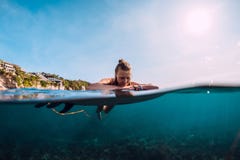 Surfingowiec kobieta relaksuje i unoszący się z surfboard Surfgirl w oceanie zdjęcie stock Surfingowiec kobieta relaksuje i unoszący się z surfboard Surfgirl w oceanie zdjęcie stock