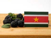 Suriname flag on a wooden panel with blackberries isolated on a Stock Image Suriname flag on a wooden panel with blackberries isolated on a Stock Image