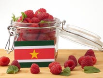 Suriname flag on a wooden panel with raspberries isolated on a w Stock Image Suriname flag on a wooden panel with raspberries isolated on a w Stock Image