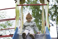 Surprised child looking down a children slide stock image Surprised child looking down a children slide stock image
