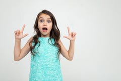 Surprised Teenager Girl In A Blue Dress Thumbs Up On An Advertisement On A White Studio Background Royalty Free Stock Photos Surprised Teenager Girl In A Blue Dress Thumbs Up On An Advertisement On A White Studio Background Royalty Free Stock Photos