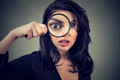 Surprised woman looking through magnifying glass Stock Photos Surprised woman looking through magnifying glass Stock Photos