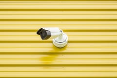 Surveillance video camera isolated on yellow royalty free stock photography Surveillance video camera isolated on yellow royalty free stock photography