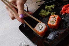 Sushi. Hand with chopsticks