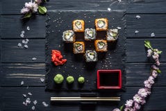 Sushi, ramo de sakura, molho de soja em uma tabela preta imagens de stock royalty free Sushi, ramo de sakura, molho de soja em uma tabela preta imagens de stock royalty free