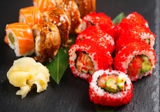 Sushi rolls closeup. Japanese food in restaurant. Roll with salmon, eel, vegetables and flying fish caviar Stock Images Sushi rolls closeup. Japanese food in restaurant. Roll with salmon, eel, vegetables and flying fish caviar Stock Images