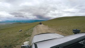 SUV едет долина с горами на горизонте Автоматическое перемещение: POV - автомобиль точки зрения двигая вдоль дороги к сток-видео SUV едет долина с горами на горизонте Автоматическое перемещение: POV - автомобиль точки зрения двигая вдоль дороги к сток-видео
