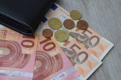 Svart plånbok med eurovalutasedlar och mynt arkivbilder Svart plånbok med eurovalutasedlar och mynt arkivbilder