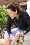 Sweatsuit наушников бутылки утомленной женщины ослабляя идущее стоковая фотография Sweatsuit наушников бутылки утомленной женщины ослабляя идущее стоковая фотография