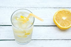 Sweaty glass with a refreshing cocktail with ice and lemon. On a wooden background. stock images Sweaty glass with a refreshing cocktail with ice and lemon. On a wooden background. stock images