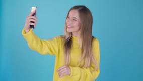 Sweet girl with a phone talking on a video call in the smartphone, looking at the phone screen with astonished face on a stock video Sweet girl with a phone talking on a video call in the smartphone, looking at the phone screen with astonished face on a stock video