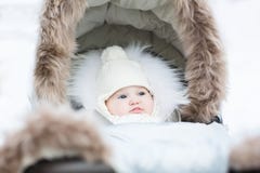 Sweet little baby sitting in a winter fur stroller royalty free stock images Sweet little baby sitting in a winter fur stroller royalty free stock images
