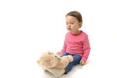 Sweet toddler girl playing with her teddy bear putting him on feet to sleep Stock Photography Sweet toddler girl playing with her teddy bear putting him on feet to sleep Stock Photography