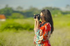 Sweet young Asian Chinese or Korean woman on her 20s taking picture with photo camera smiling happy in beautiful nature landscape. In holidays and photographer Royalty Free Stock Photo Sweet young Asian Chinese or Korean woman on her 20s taking picture with photo camera smiling happy in beautiful nature landscape. In holidays and photographer Royalty Free Stock Photo