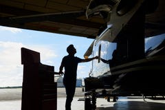 Sylwetka Męski Aero inżynier Pracuje Na helikopterze W hangarze zdjęcia stock Sylwetka Męski Aero inżynier Pracuje Na helikopterze W hangarze zdjęcia stock