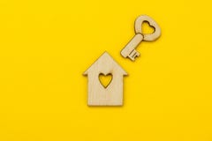 Symbol av ett litet hus och en tangent med en hjärta på en gul bakgrund arkivbild Symbol av ett litet hus och en tangent med en hjärta på en gul bakgrund arkivbild