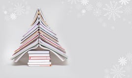 Symbol Christmas tree from a colorful books on grey background.