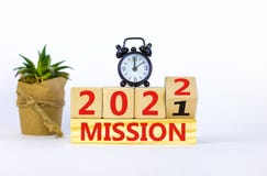 Symbol of planning 2022 mission new year. Alarm clock. Turned a wooden cube, changed words `mission 2021` to `mission 2022`.