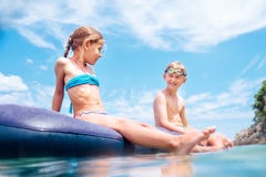 Systern och brodern, har gyckel n?r badet p? den uppbl?sbara madrassen i havet Of?rsiktig barndomtid arkivfoto Systern och brodern, har gyckel n?r badet p? den uppbl?sbara madrassen i havet Of?rsiktig barndomtid arkivfoto