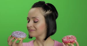 Szcz??liwa pi?kna m?oda dziewczyna pozuje zabaw? z donuts i ma Chroma klucz zdjęcie wideo Szcz??liwa pi?kna m?oda dziewczyna pozuje zabaw? z donuts i ma Chroma klucz zdjęcie wideo