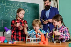 szcz??liwy dziecko nauczyciel robi? eksperymentom z cieczami w chemii lab Chemii lab tylna szko?y dzieciaki w lab zdjęcie stock szcz??liwy dziecko nauczyciel robi? eksperymentom z cieczami w chemii lab Chemii lab tylna szko?y dzieciaki w lab zdjęcie stock