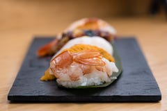 Szczegół odparowany krewetki nigiri z tłem nigiri z Pacyficznym Dennym czesakiem, dekatyzował łososia, odparowana garnela, kawior zdjęcie stock Szczegół odparowany krewetki nigiri z tłem nigiri z Pacyficznym Dennym czesakiem, dekatyzował łososia, odparowana garnela, kawior zdjęcie stock