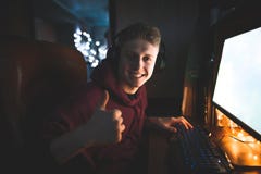 Szczęśliwy młody człowiek bawić się gry na komputerze, siedzący w domu w cmentarzu, patrzeje w kamerę obrazy royalty free Szczęśliwy młody człowiek bawić się gry na komputerze, siedzący w domu w cmentarzu, patrzeje w kamerę obrazy royalty free