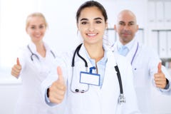 Szczęśliwa doktorska kobieta z medycznym personelem przy szpitalem Aprobaty i Ok znak obraz royalty free Szczęśliwa doktorska kobieta z medycznym personelem przy szpitalem Aprobaty i Ok znak obraz royalty free