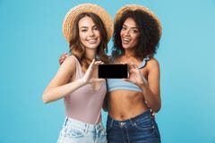 Szczęśliwa fotografia dwa wieloetnicznej lato dziewczyny ono uśmiecha się i pokazuje obrazy royalty free Szczęśliwa fotografia dwa wieloetnicznej lato dziewczyny ono uśmiecha się i pokazuje obrazy royalty free
