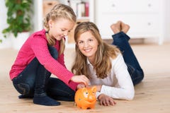 Szczęśliwa mała dziewczynka ratuje jej kieszeniowego pieniądze zdjęcia stock Szczęśliwa mała dziewczynka ratuje jej kieszeniowego pieniądze zdjęcia stock