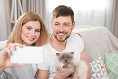Szczęśliwa para bierze fotografię z kotem zdjęcie royalty free Szczęśliwa para bierze fotografię z kotem zdjęcie royalty free
