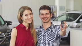  Szczęśliwa para pozuje z samochodów kluczami ich nowy samochód Fotografia Stock