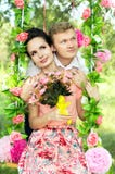 Szczęśliwa potomstwo pary jazda na huśtawce obraz stock Szczęśliwa potomstwo pary jazda na huśtawce obraz stock