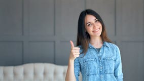 Szczęśliwa uśmiechnięta młoda kobieta pokazuje sukces i gestykuluje aprobaty indoors zdjęcie wideo Szczęśliwa uśmiechnięta młoda kobieta pokazuje sukces i gestykuluje aprobaty indoors zdjęcie wideo