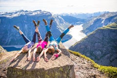 Szczęśliwi ludzie relaksują w falezie podczas wycieczki Norwegia Trolltunga wycieczkuje trasę obraz royalty free Szczęśliwi ludzie relaksują w falezie podczas wycieczki Norwegia Trolltunga wycieczkuje trasę obraz royalty free