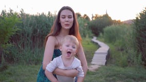 Szczęśliwy dzieciństwo, młody rozochocony mum bawić się z słodką chłopiec która lata w powietrzu przy macierzystymi rękami zbiory wideo Szczęśliwy dzieciństwo, młody rozochocony mum bawić się z słodką chłopiec która lata w powietrzu przy macierzystymi rękami zbiory wideo