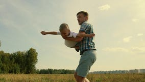 Szczęśliwy ojciec bawić się z jego synem podnosi on up w jego rękach Chłopiec wyobraża sobie go lata jak samolot zbiory wideo Szczęśliwy ojciec bawić się z jego synem podnosi on up w jego rękach Chłopiec wyobraża sobie go lata jak samolot zbiory wideo