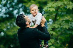 Szczęśliwy radosny ojciec ma zabawę rzuca jego małego dziecka w powietrzu fotografia royalty free Szczęśliwy radosny ojciec ma zabawę rzuca jego małego dziecka w powietrzu fotografia royalty free