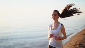 Szczęśliwy uśmiechnięty sport kobiety bieg na piasek plaży blisko morza zdjęcie wideo Szczęśliwy uśmiechnięty sport kobiety bieg na piasek plaży blisko morza zdjęcie wideo