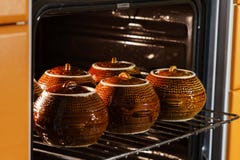Sześć gorących brown glinianych ceramicznych garnków z podpartym lub stewed jedzeniem wśrodku piekarnika obraz royalty free Sześć gorących brown glinianych ceramicznych garnków z podpartym lub stewed jedzeniem wśrodku piekarnika obraz royalty free