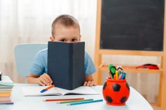 Szkolna chłopiec siedzi sali lekcyjnej łgarskiego biurko w domu wypełniał z książka stażowego materiału uczniem śpi gnuśnego zanu zdjęcia royalty free Szkolna chłopiec siedzi sali lekcyjnej łgarskiego biurko w domu wypełniał z książka stażowego materiału uczniem śpi gnuśnego zanu zdjęcia royalty free